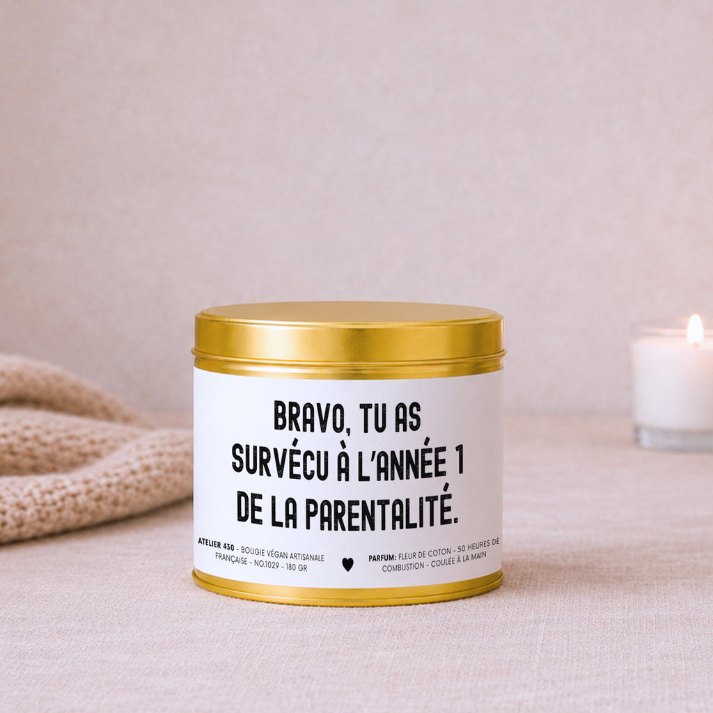 Bougie avec texte « Bravo, tu as survécu à l’année 1 de la parentalité » avec boîte or – Atelier 430